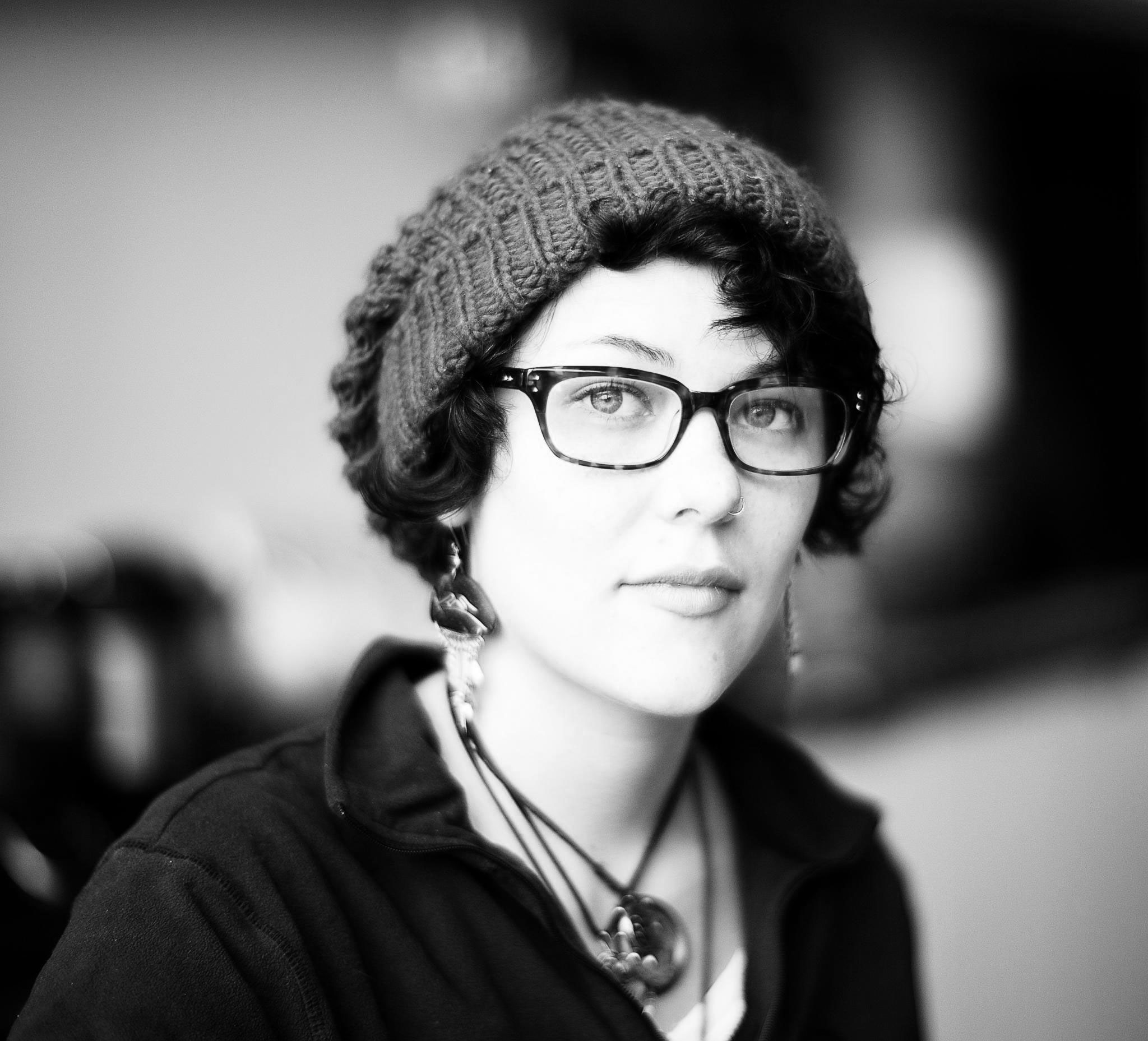 A woman wearing glasses and a hat.
