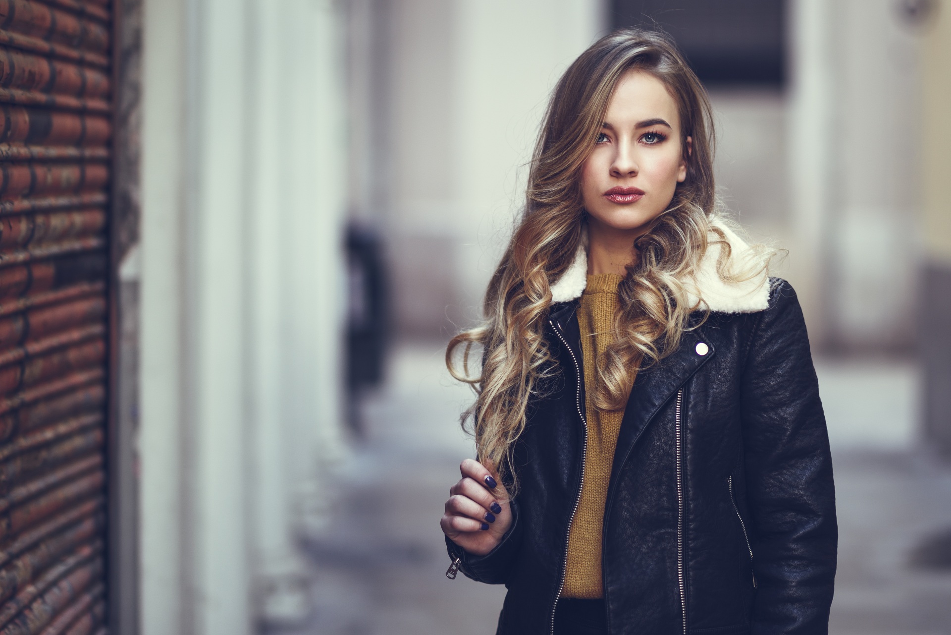 A woman with long hair wearing a leather jacket.